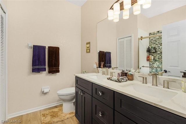 bathroom with toilet, vanity, and hardwood / wood-style flooring