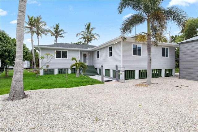 view of front of home featuring gravel driveway and a front yard