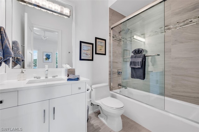 full bathroom with bath / shower combo with glass door, vanity, and toilet