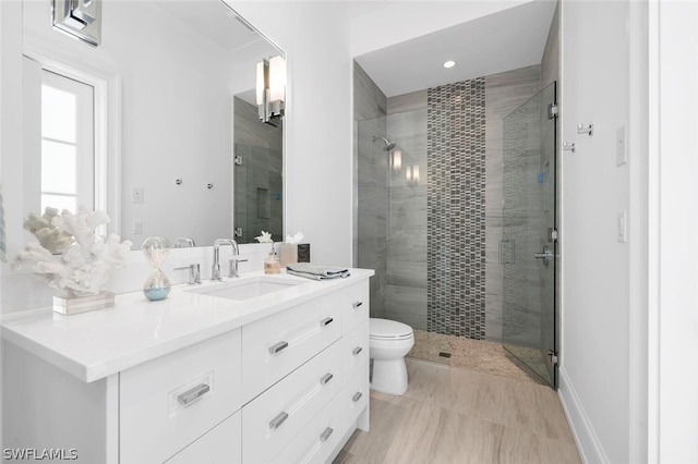 bathroom with walk in shower, vanity, and toilet