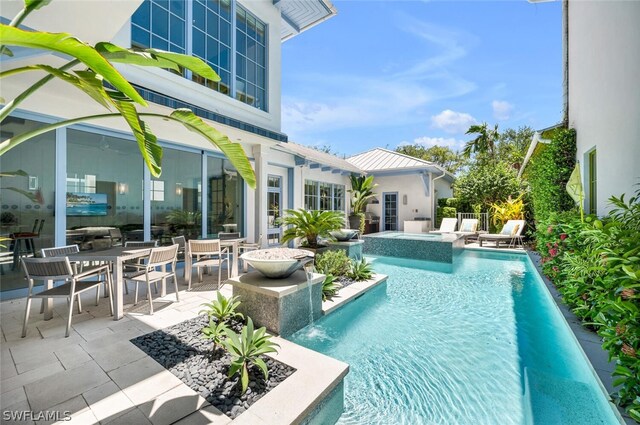 view of pool with a patio, pool water feature, and an in ground hot tub