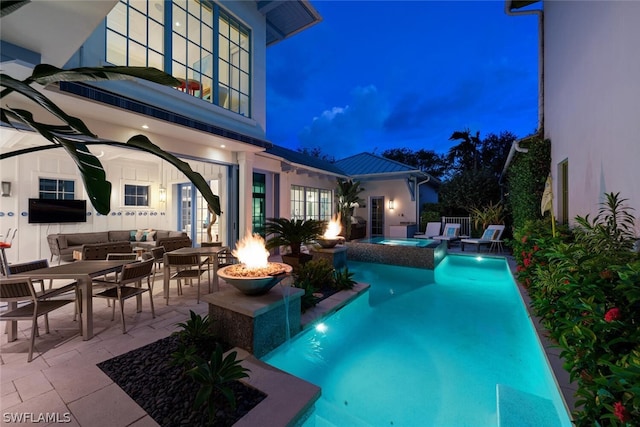 view of pool featuring a patio area, an outdoor living space with a fire pit, pool water feature, and an in ground hot tub