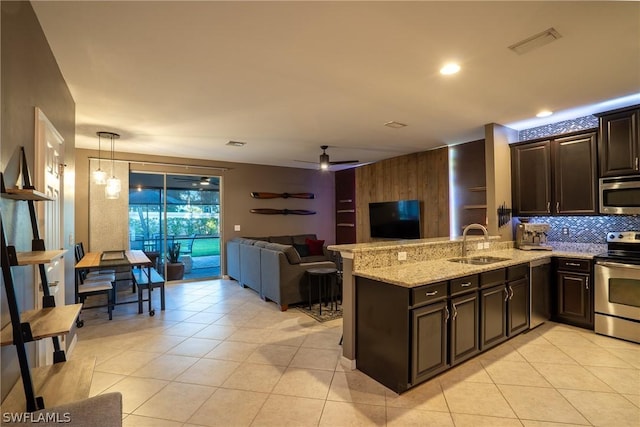 kitchen featuring ceiling fan, sink, stainless steel appliances, kitchen peninsula, and decorative light fixtures