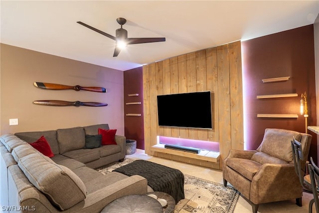 living room with ceiling fan and wooden walls