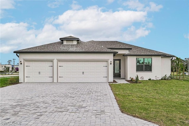 prairie-style home featuring a garage, a shingled roof, decorative driveway, a front lawn, and stucco siding