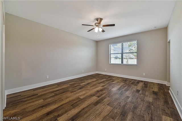 unfurnished room with a ceiling fan, dark wood-style flooring, and baseboards