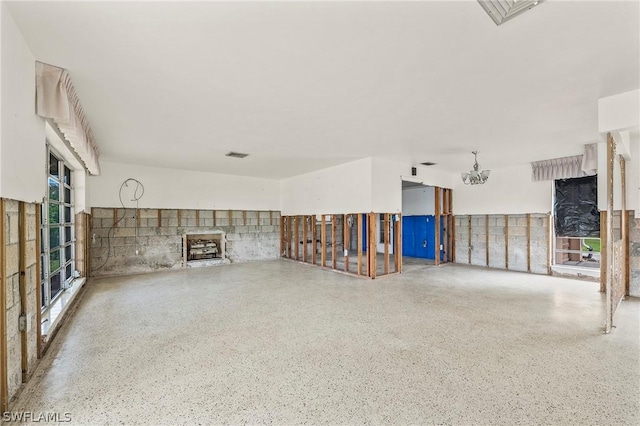 unfurnished living room with a notable chandelier