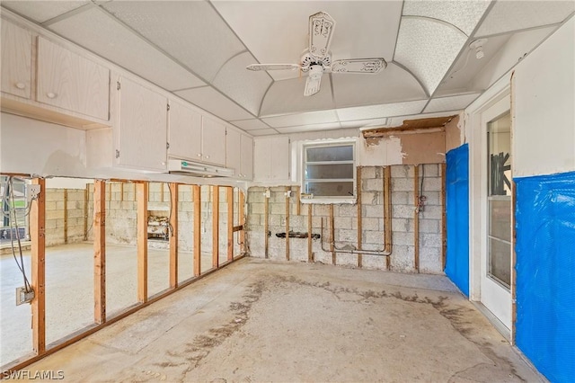 basement featuring ceiling fan and a drop ceiling