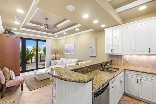 kitchen with kitchen peninsula, white cabinets, and sink