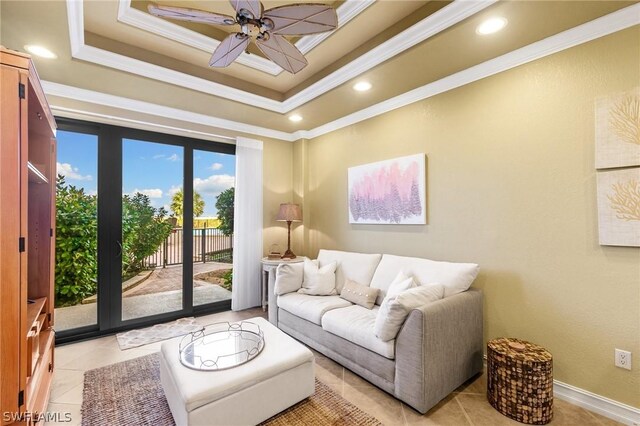 living room with ceiling fan, ornamental molding, light tile patterned floors, and a tray ceiling