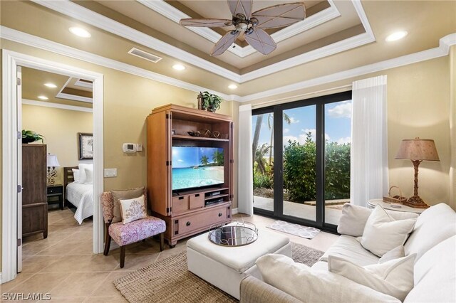 living room with a tray ceiling, crown molding, and ceiling fan