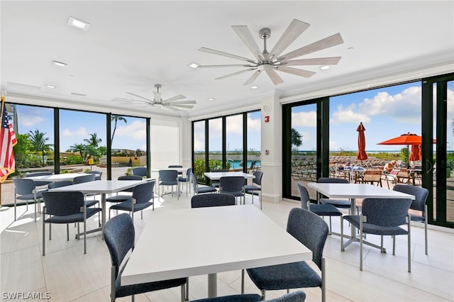 dining space with ceiling fan and a wall of windows