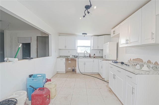 kitchen featuring sink, white cabinets, and light tile patterned floors