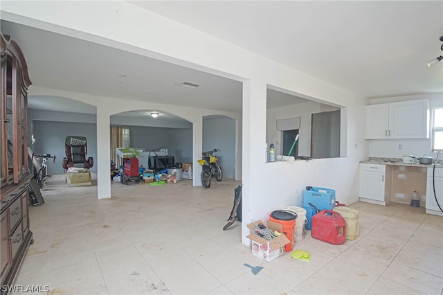 interior space with white cabinetry, light tile patterned floors, and light stone countertops