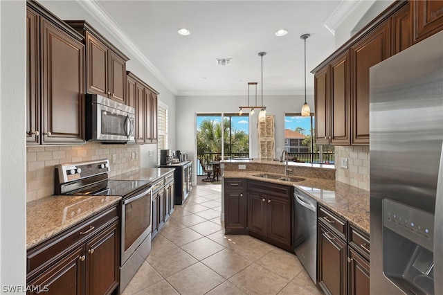 kitchen featuring sink, backsplash, pendant lighting, appliances with stainless steel finishes, and ornamental molding