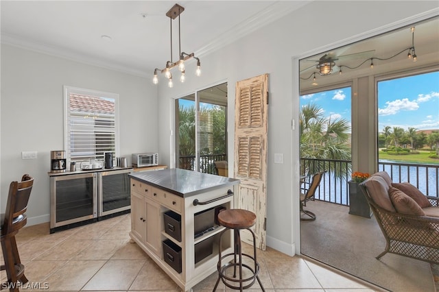 kitchen featuring white cabinetry, light tile patterned floors, hanging light fixtures, and ornamental molding