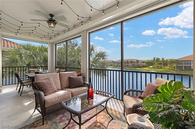 sunroom with ceiling fan, a water view, and a healthy amount of sunlight