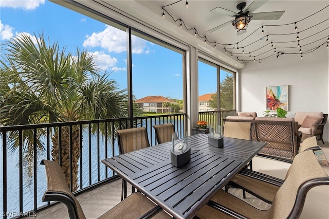 sunroom / solarium featuring ceiling fan and a water view