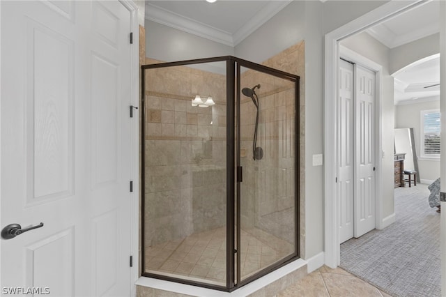 bathroom featuring tile patterned flooring, a shower with shower door, and ornamental molding