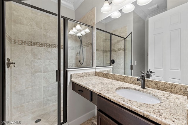 bathroom featuring vanity, a shower with shower door, and ornamental molding