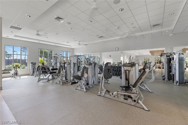 exercise room with a drop ceiling and ceiling fan