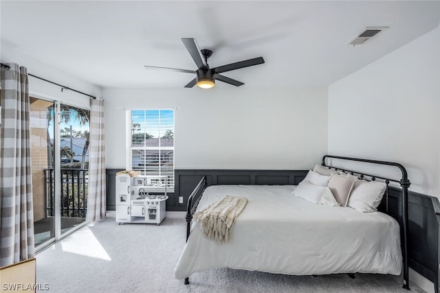 bedroom featuring carpet, visible vents, ceiling fan, wainscoting, and access to outside