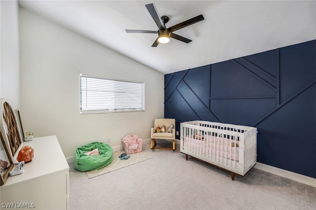 carpeted bedroom with a nursery area, ceiling fan, and lofted ceiling