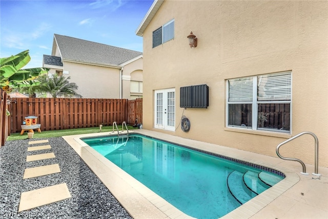 view of pool featuring french doors, a patio, a fenced in pool, and a fenced backyard