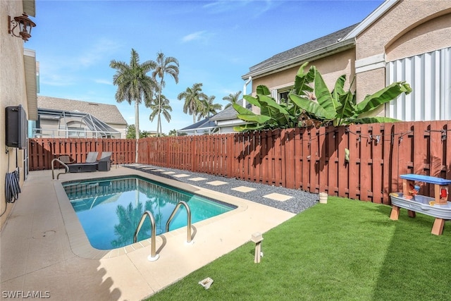 view of pool with a patio, a fenced backyard, and a lawn