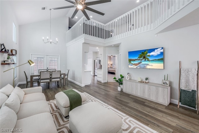 living room with ceiling fan with notable chandelier, french doors, high vaulted ceiling, and dark hardwood / wood-style floors