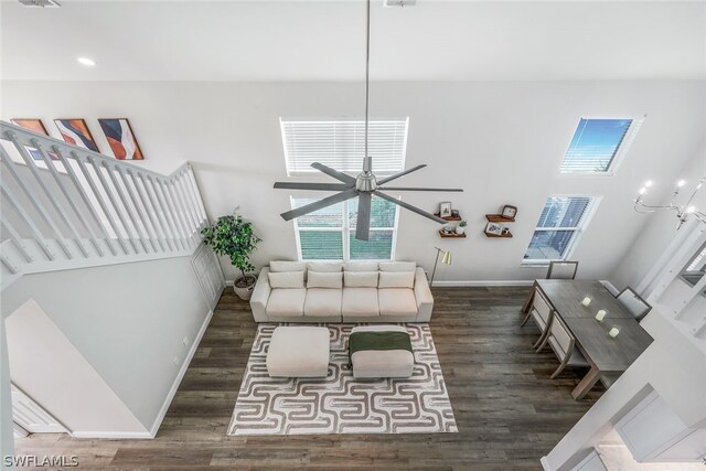 living room featuring ceiling fan and dark wood-type flooring