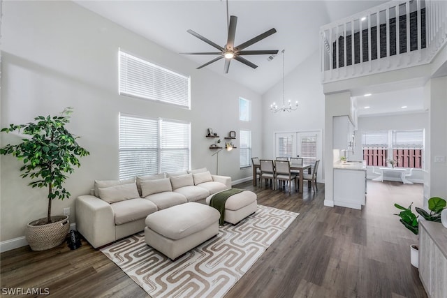 living room featuring a towering ceiling, dark hardwood / wood-style flooring, and a wealth of natural light