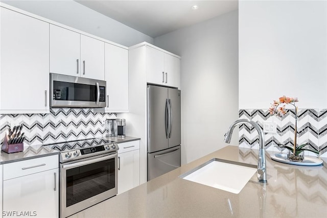 kitchen with sink, white cabinetry, backsplash, and appliances with stainless steel finishes