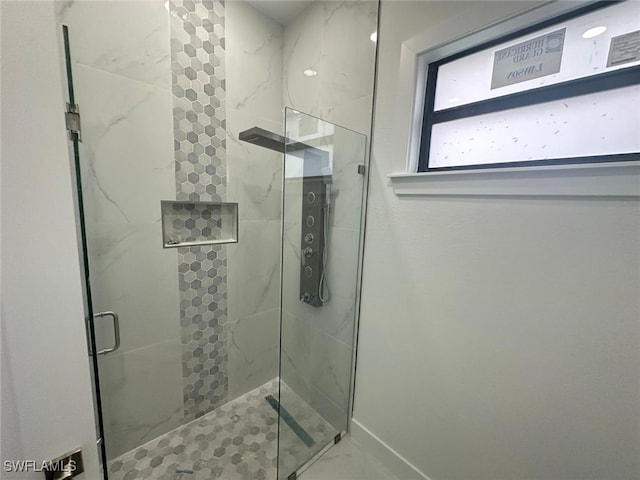 bathroom with a shower with door