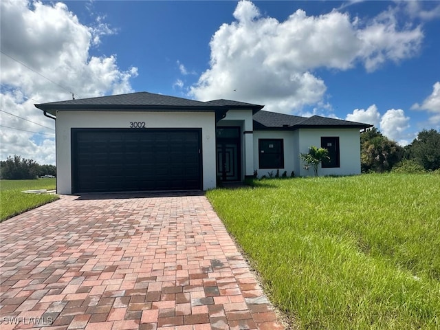 view of front of home featuring a front yard and a garage