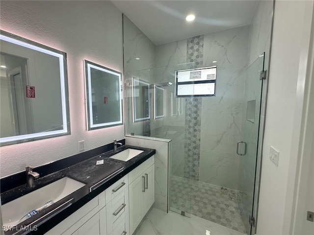 bathroom with a shower with door, vanity, and a wealth of natural light