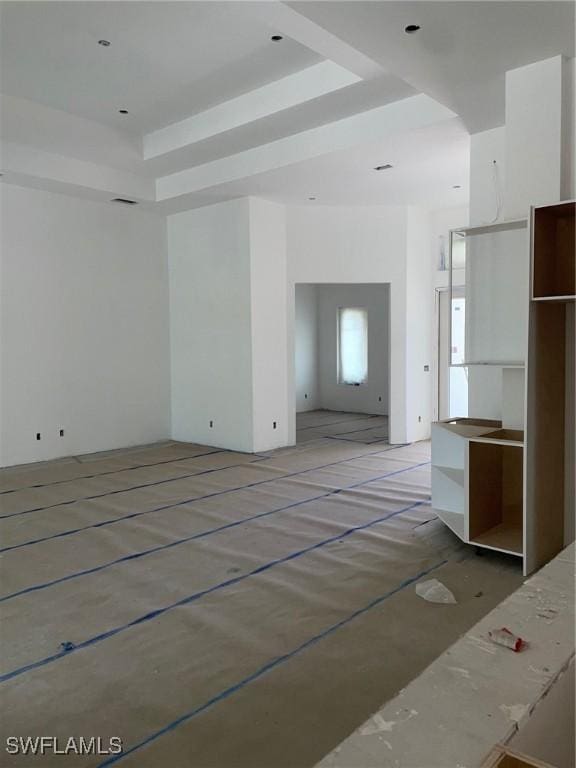 unfurnished living room with a raised ceiling