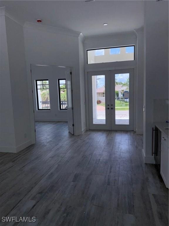 interior space with crown molding, baseboards, french doors, and wood finished floors