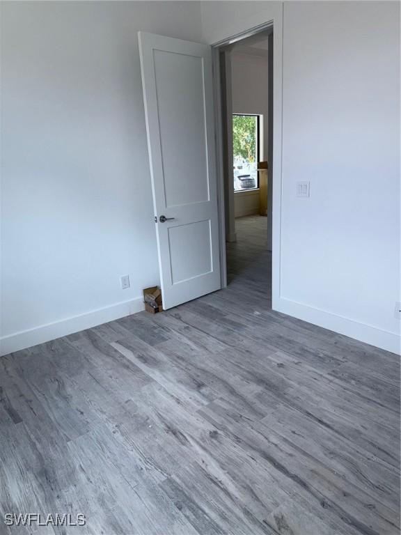 empty room featuring baseboards and wood finished floors