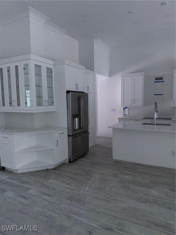 kitchen featuring a sink, open shelves, high quality fridge, and white cabinetry