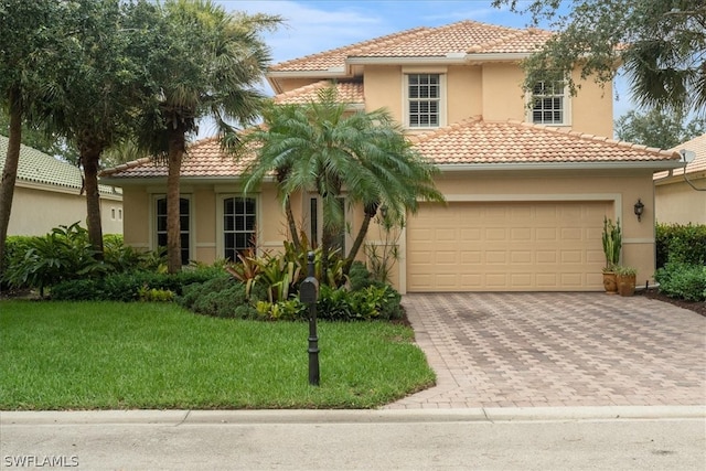 mediterranean / spanish home with a garage and a front lawn