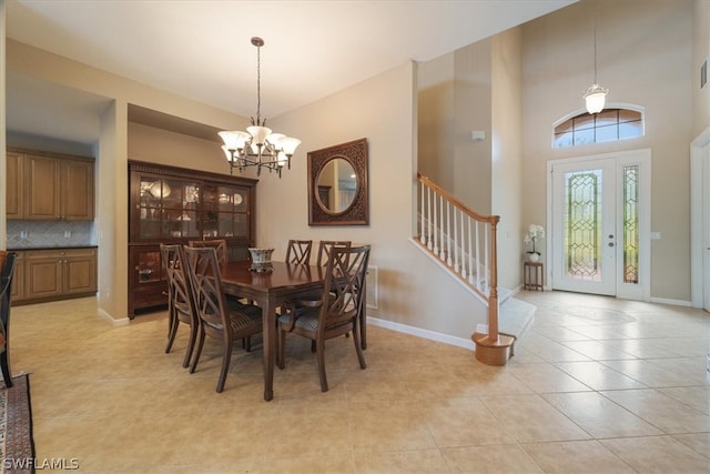 dining area featuring a high ceiling, a chandelier, and light tile patterned floors