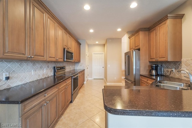 kitchen with sink, appliances with stainless steel finishes, light tile patterned flooring, and backsplash