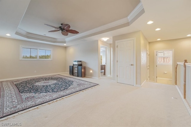 carpeted living room featuring ceiling fan, crown molding, and a tray ceiling