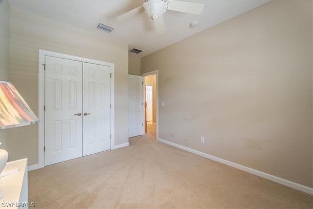 unfurnished bedroom with light carpet, a closet, and ceiling fan