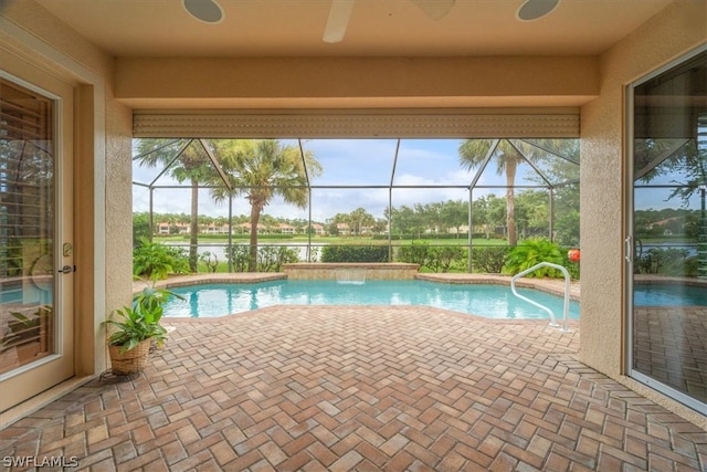 view of swimming pool with pool water feature, glass enclosure, and a patio area