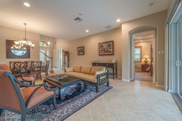 tiled living room featuring a notable chandelier