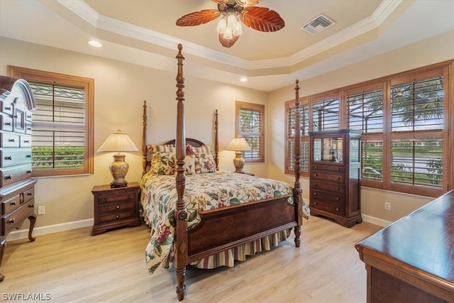 bedroom with ceiling fan, light hardwood / wood-style flooring, a raised ceiling, and ornamental molding