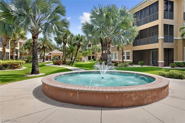 view of pool featuring pool water feature and a lawn