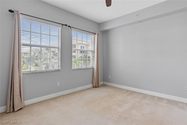 carpeted spare room with ceiling fan